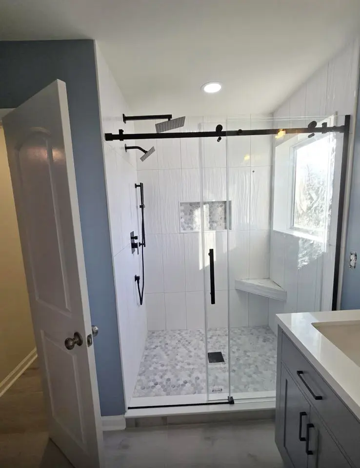 Modern glass shower with black fixtures and tile